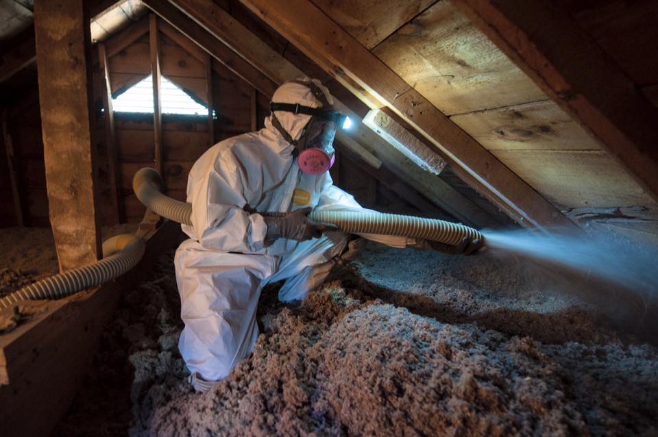 Greenserve employee adding in insulation to an attic