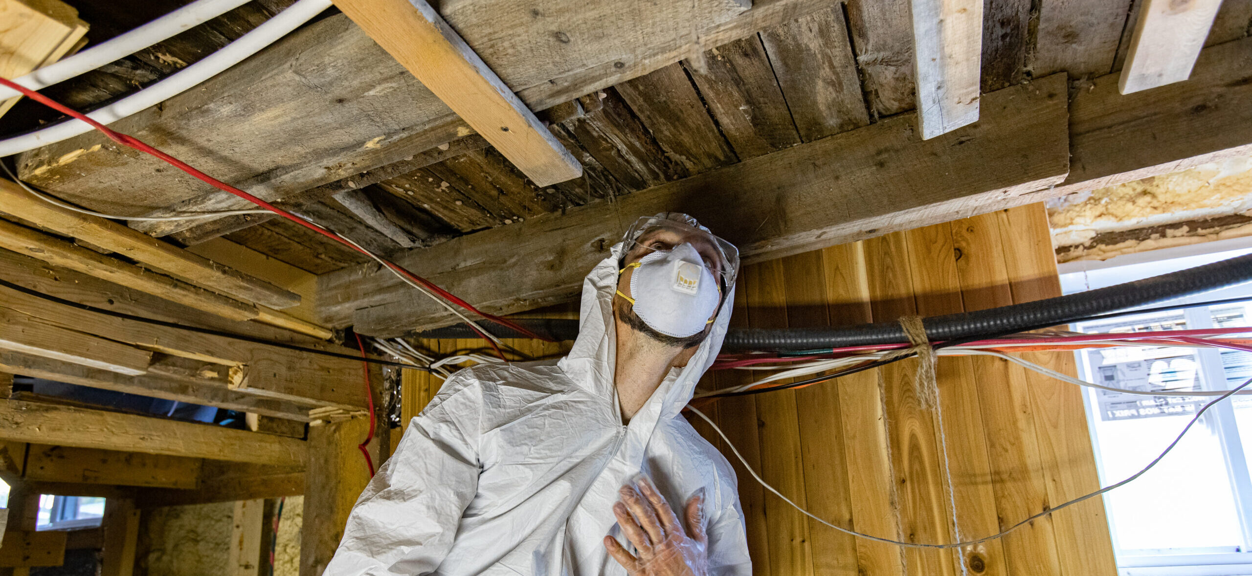man in mold prevention gear in a crawlspace